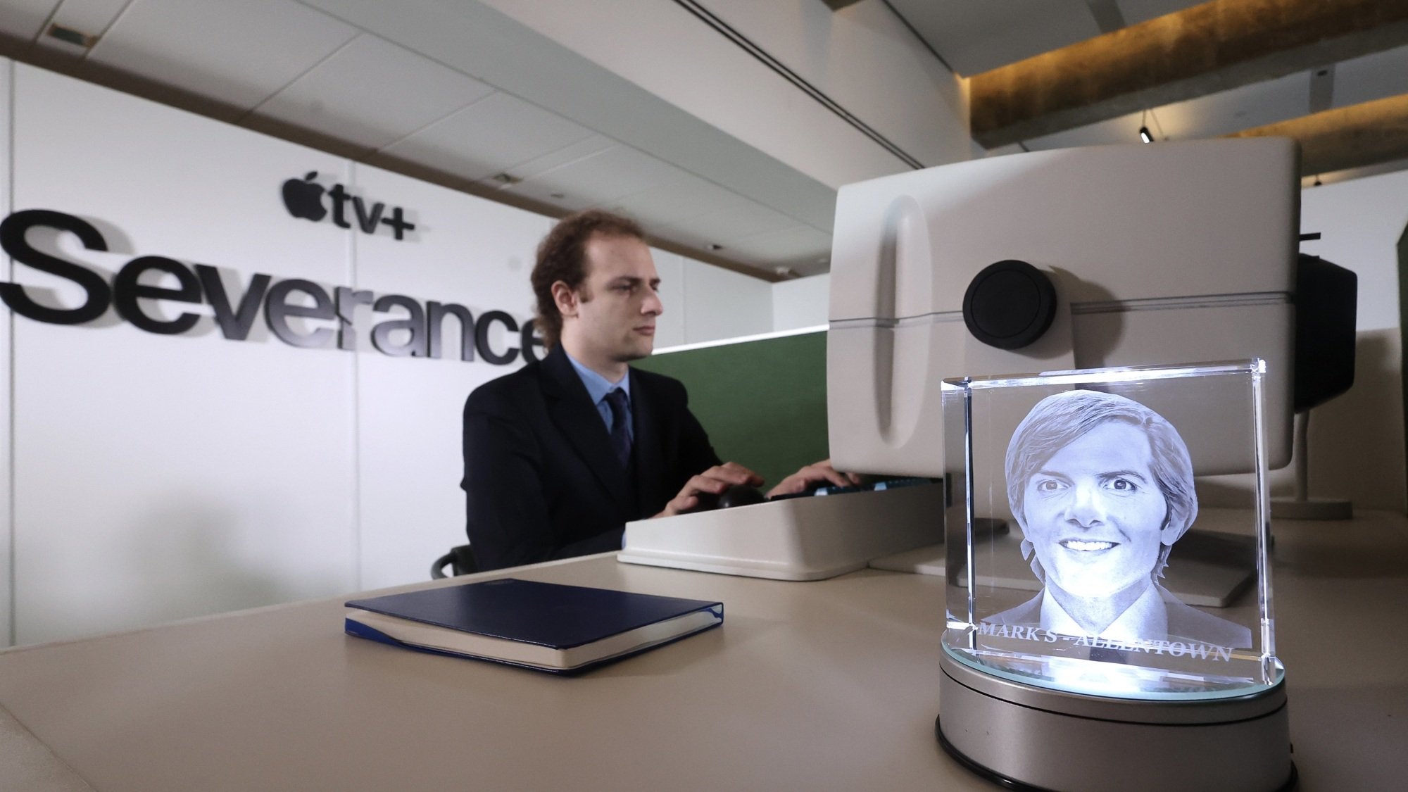 An actor sits at a replica of Mark S.'s desk from "Severance."