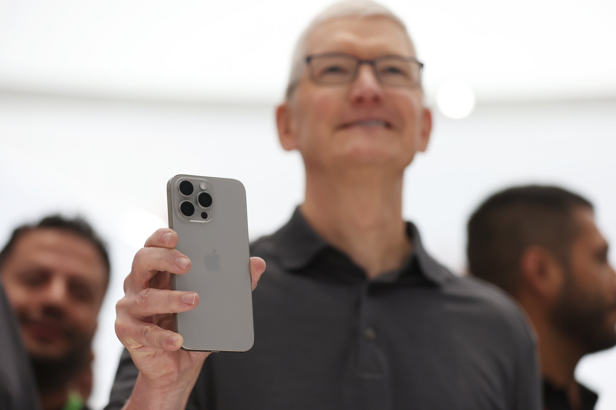 Apple CEO Tim Cook holds an iPhone 15
