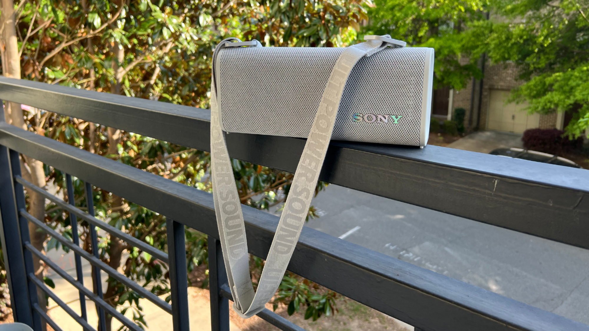 sony speaker with shoulder strap sitting on a blacony edge