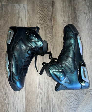 Pair of iridescent blue Air Jordan sneakers on hardwood floor