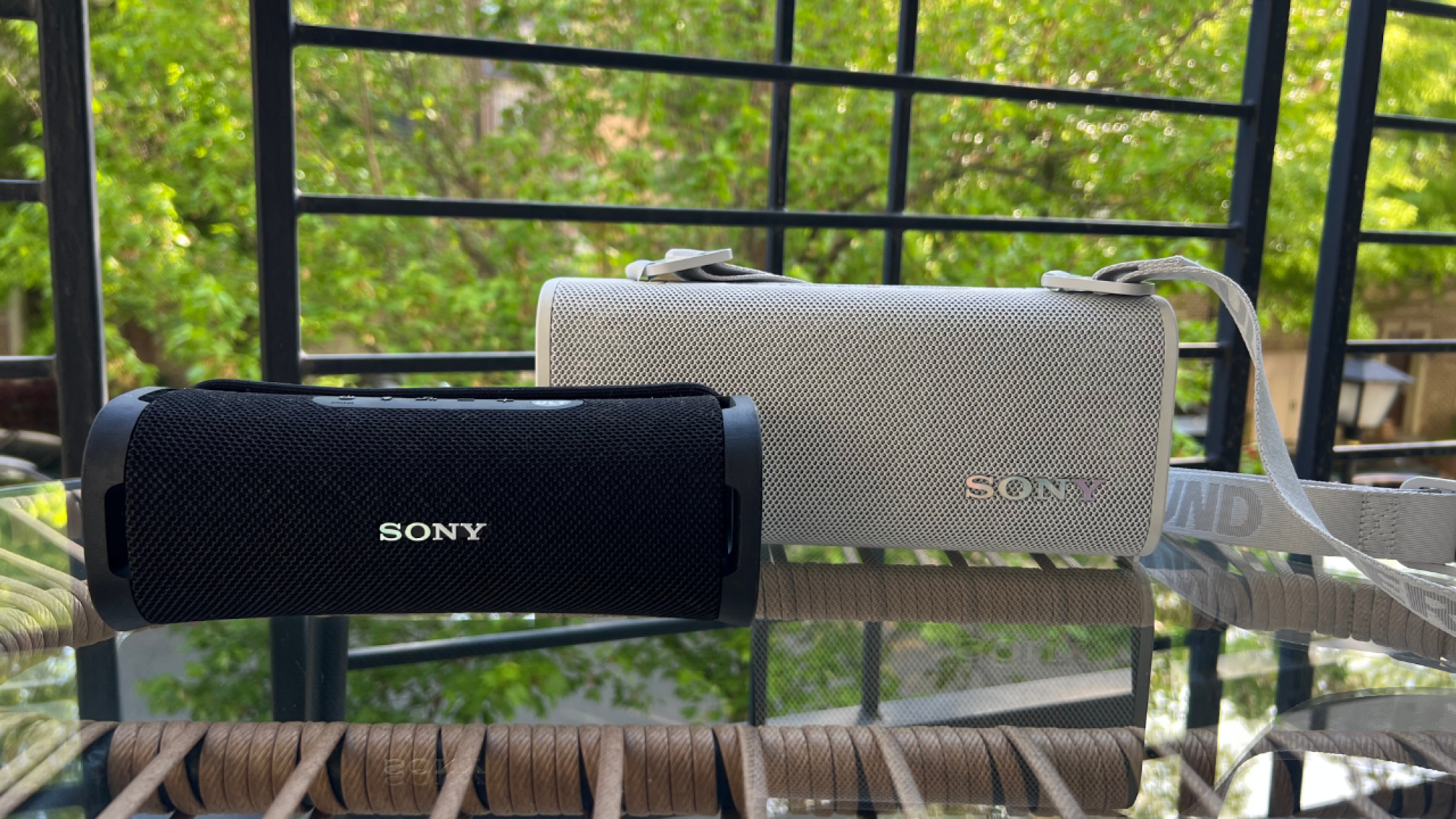 black sony ult field 1 speaker on a table with the off white sony ult field 3 speaker