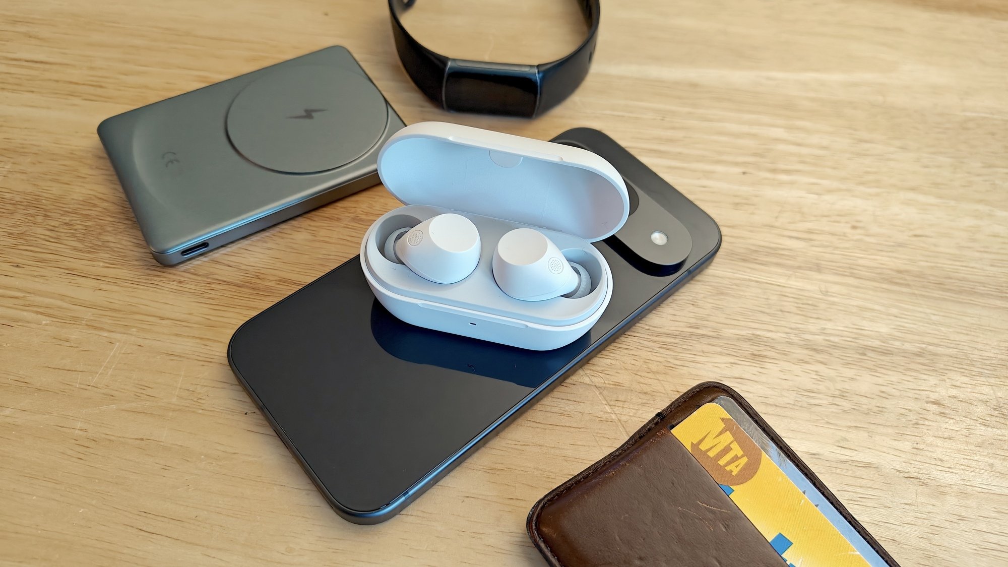 sony earbuds in their case sitting on a phone