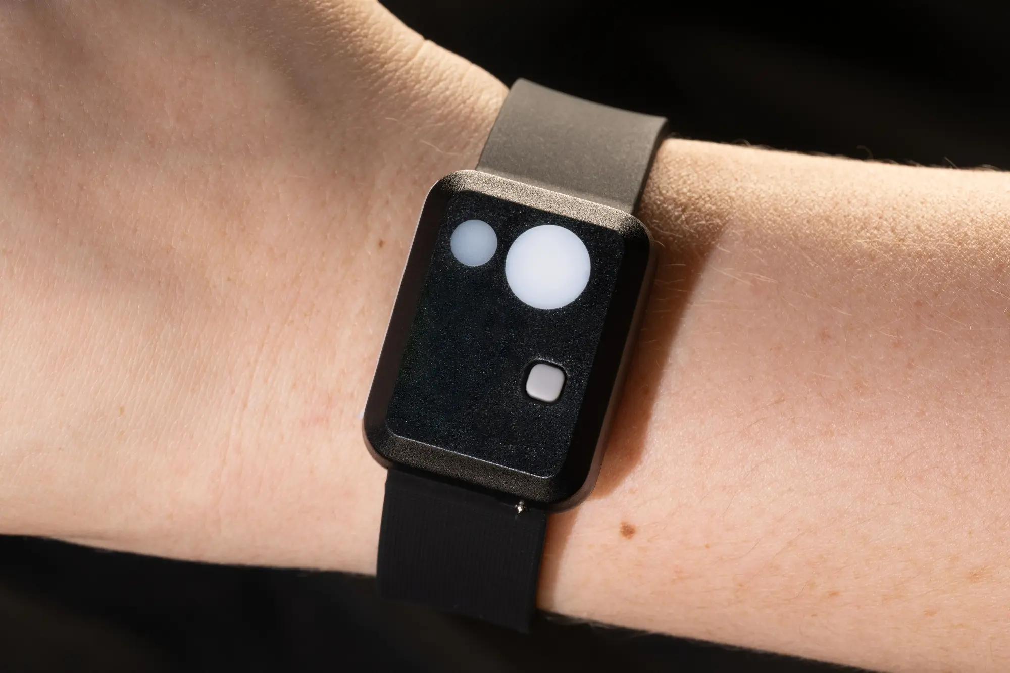 A person modeling the Artemis 2 Archer actigraphy wristband device